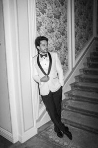 Groom standing on stairs in tuxedo editorial style wedding photo in Italy