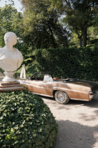 Vintage car under trees luxury wedding in Tuscany
