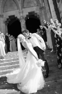 Just married couple leaving a church in Mallorca, surrounded by guests