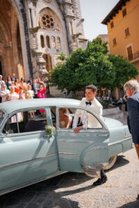 Newlyweds arriving at Mallorca wedding venue in vintage car