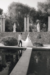 Bride and groom walking near pool at Mallorca wedding venue