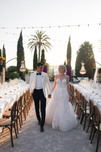 Bride and groom walking through sunset-lit reception in Mallorca