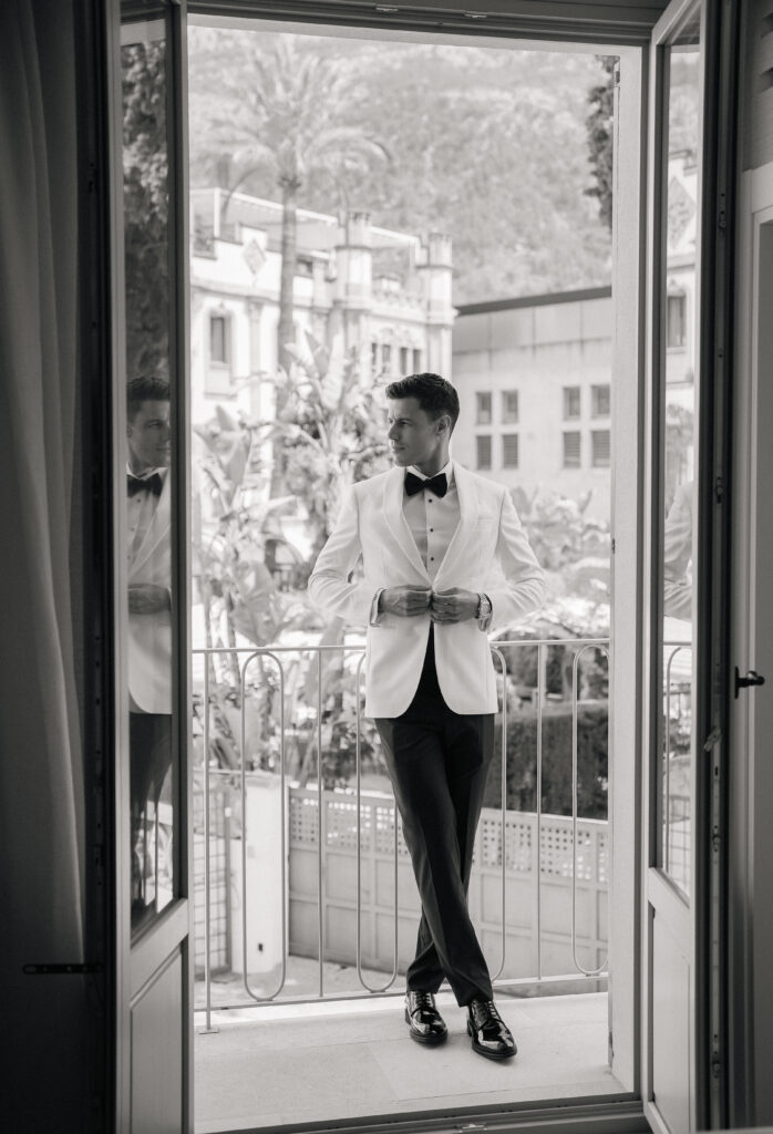 groom in white tuxedo on balcony in Soller town mallorca wedding photographer